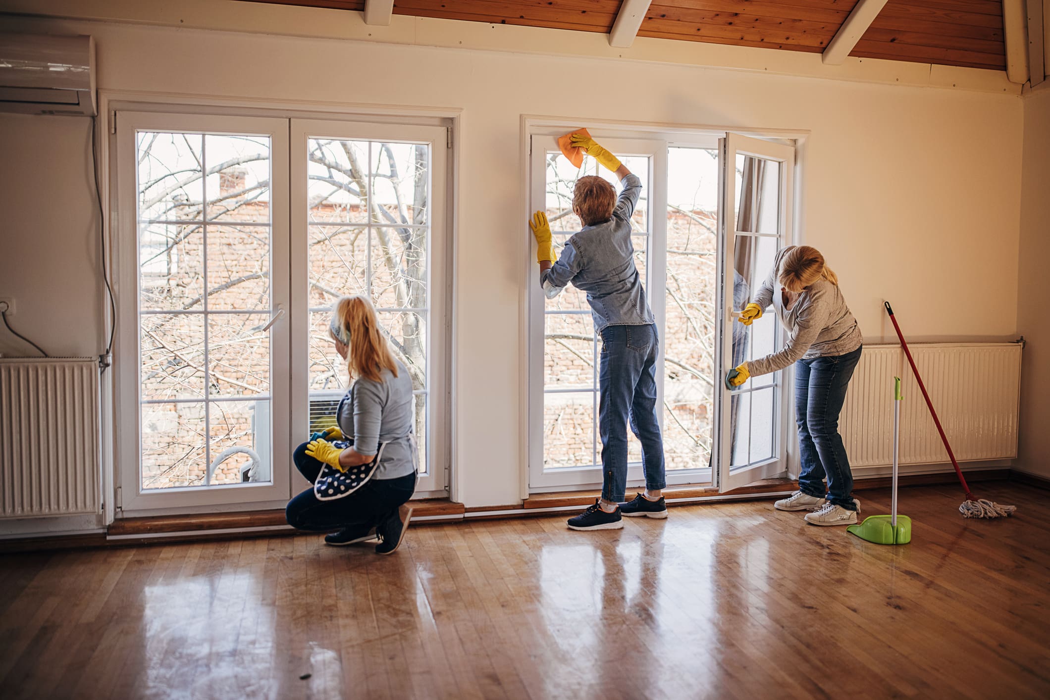 Three people washing glass doors