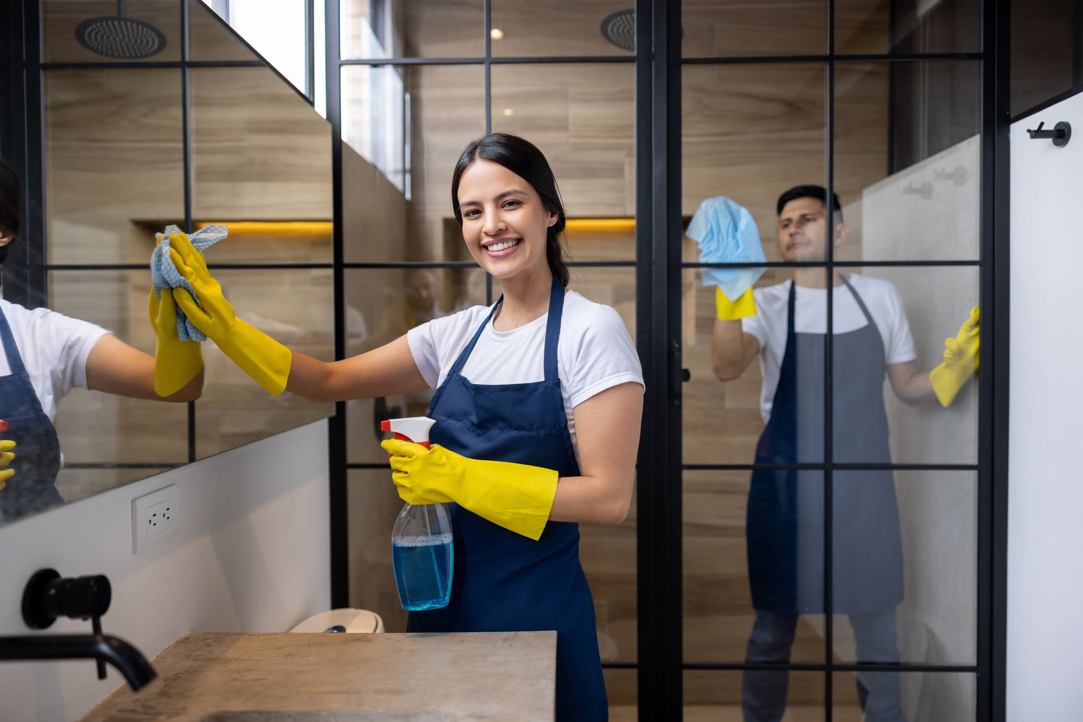 Smiling cleaners in aprons working