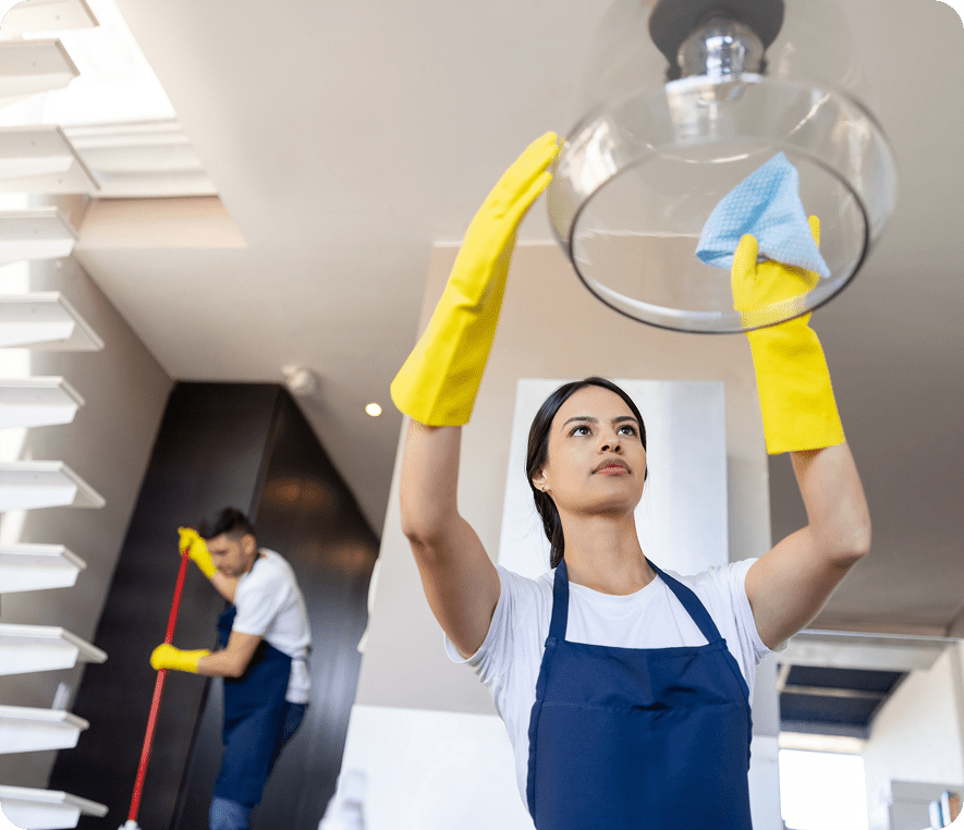 Woman cleaning light fixture with cloth