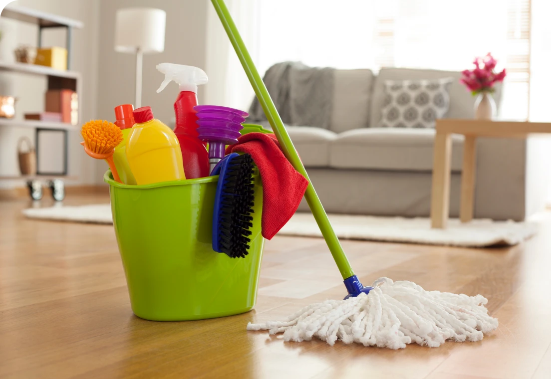 Cleaning supplies and mop on wooden floor